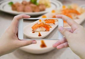 tomando fotos de sushi de salmón a la parrilla