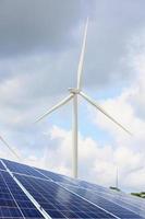 solar panels and wind turbines with the clouds and sky photo