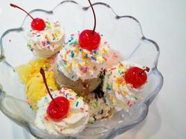 Ice cream scoops with whipped cream and cherry photo