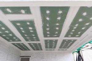 ceiling gypsum board installation at construction site photo