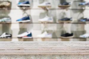 mesa de madera con zapatos en los estantes de la tienda de zapatos foto