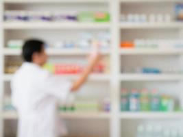 blur pharmacist taking medicine from shelf in the pharmacy photo