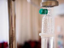 Medical drip with hospital blurred background photo