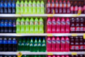 Blur soft drink beverage shelves display in supermarket photo