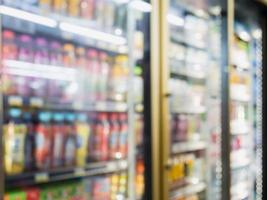 blur bottles of beverage on shelves in the freezer at supermarket photo