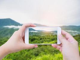 tomando fotos del paisaje montañoso con nubes