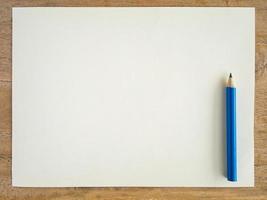 Blank paper with pencil on wood table photo