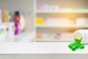 medicine pills on counter with blur shelves of drug in the pharmacy photo