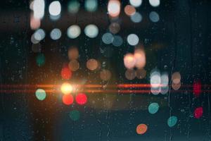 drops on the window with street lights background at night photo