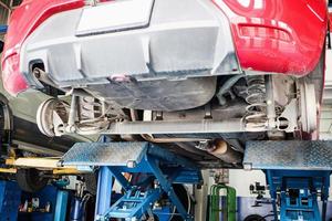 coche en ascensores en el centro de servicio automático para mantenimiento y sustitución de neumáticos foto