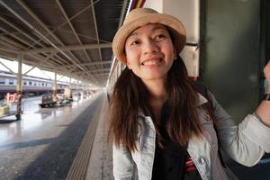Happy Asian woman travel by traditional train in Thailand photo