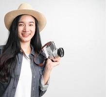mujer asiática sosteniendo una cámara vintage con espacio de copia. concepto de viaje foto