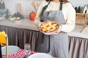 woman preparing pumpkin pie for thanksgiving dinner at home kitchen photo