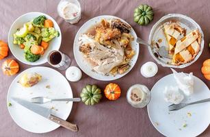 top view of thanksgiving table after feast, leftovers and dirty dishes photo