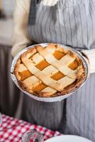 woman preparing pumpkin pie for thanksgiving dinner at home kitchen photo