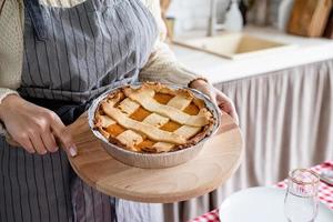 closeup of a woman hands holding pumpkin pie at home kitchen photo