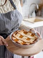 closeup of a woman hands holding pumpkin pie at home kitchen photo