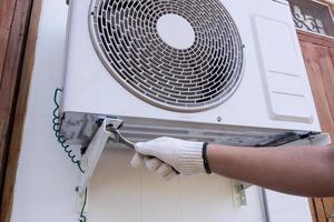 technician installing outdoor air conditioning unit photo