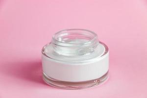 Bottle with cosmetic cleanser on pink background. Skin care concept. photo