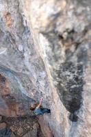 A woman climbs a rock photo