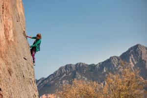 A woman climbs a rock photo