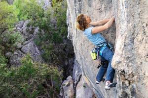 A woman climbs a rock photo