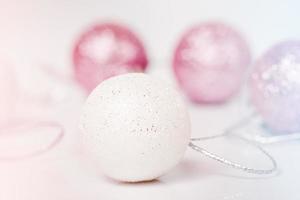 Christmas toys in white and pink on a light background. Christmas theme. Ornament. photo