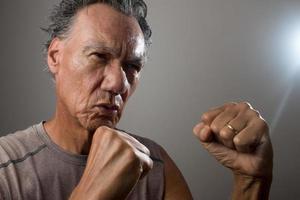 Mature Man 60 plus practicing shadow boxing by himself photo