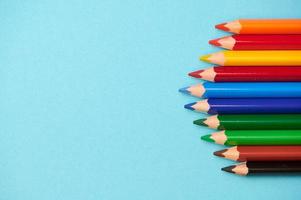 multicolored crayons on the right side on blue background with copy space for any text photo