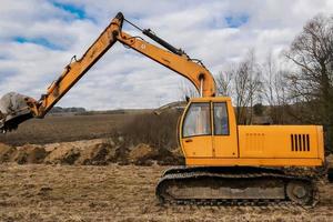 yellow excavator digging the ground photo