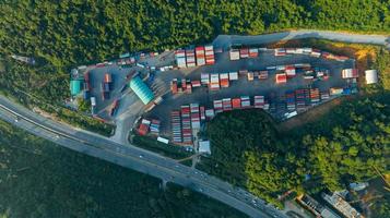 The Cargo Container yard next the road and surrounded by mountains , forklift truck and cargo at depot working load unload shipping transportation and service to customer concept logistic express