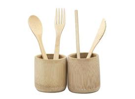 Bamboo wood cutlery, disposable fork, spoon,knife and straw in bamboo cup made of natural material isolated on white background. Ecological concept. photo