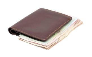 Brown genuine leather wallet with banknotes isolated on white background. photo