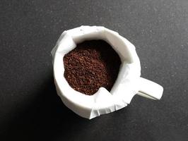 Coffee grounds in coffee with filter  on black granite counter photo