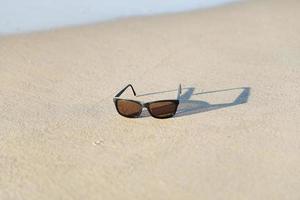 gafas de sol con shawdow en la playa de arena foto