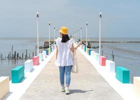 la vista trasera de una mujer asiática caminando por el puente del arco iris para ver el mirador en la provincia de samut sakorn, una de las provincias de tailandia. foto