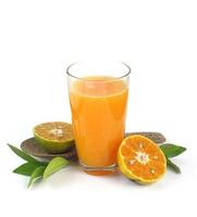 Glass of fresh and delicious orange juice with half of orange and leaves on white background