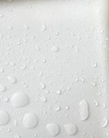 Water droplets on a white background. For background about drizzling rain with natural drops. photo