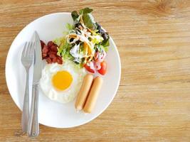 un primer plano de huevos, tocino, jamón y salchicha encima de una tostada foto