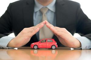 Businessman holding car photo