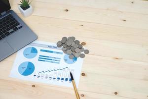 Coins stacks with notebook laptop computer and financial graph photo