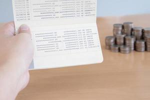 Woman hold passbook on hand, coins background photo