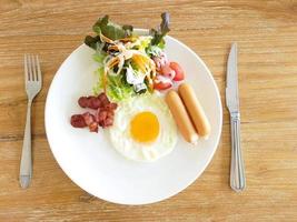 A closeup of eggs, bacon, ham, and sausage on top of toast photo