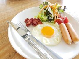 A closeup of eggs, bacon, ham, and sausage on top of toast photo