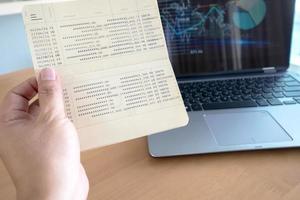 Woman hold passbook on hand,laptop background photo