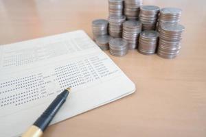 coins and pen on savings account passbook photo