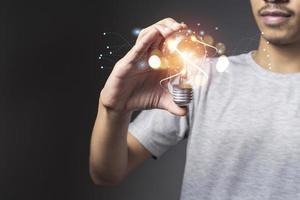 man holding Light bulbs with digital connection line outside. Creative and innovation inspiration. photo