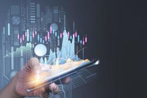 Man using mobile phone checking stock market graph report via mobile apps photo