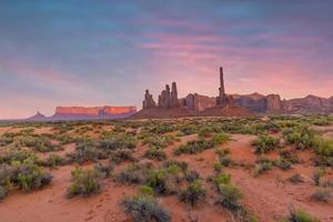 Totem pole and sand dunes  in Monument Valley, Arizona USA photo