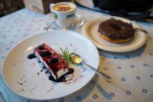 Tarta de queso con arándanos. rebanada única de tarta de queso simple adornada con arándanos frescos y menta. foto